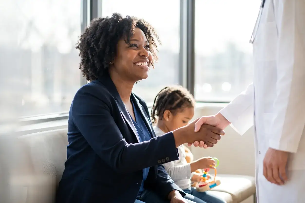 Family medicine doctor greeting a patient with a handshake in Houston
